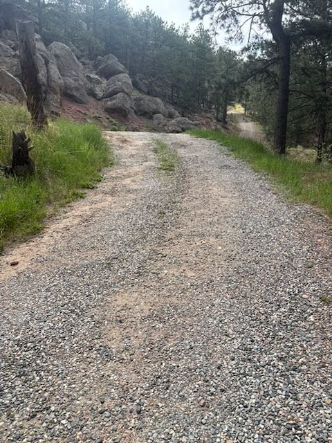 Before — deteriorated gravel driveway with compacted tire tracks, Boulder County CO